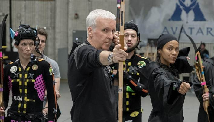 O cineasta James Cameron, ao centro, rodado de equipe, ao lado da atriz Zoe Saldaña no set de filmagens de 'Avatar: Fogo e Cinzas' Macaque in the trees