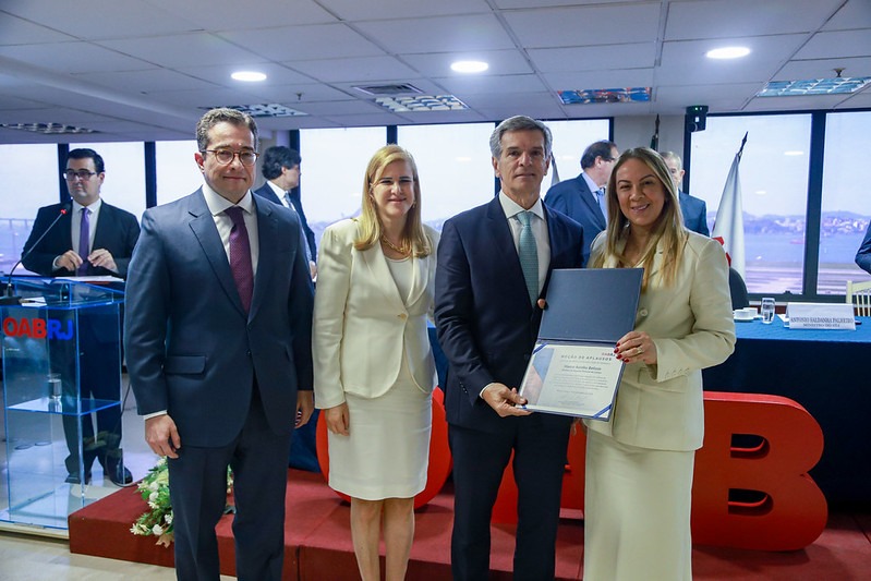 O tesoureiro da OAB-RJ, Fábio Nogueira, e a vice-presidente da Seccional, Sylvia Drumond, entregam moção de aplauso ao ministro do STJ, Marco Aurélio Bellizze, ao lado da presidente Ana Tereza Basilio